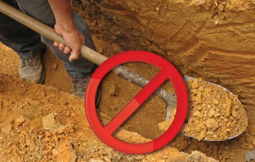 No symbol over a shovel in a dirt trench indicating no need for trenching