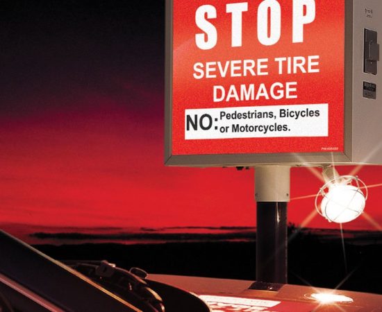 DoorKing 1610 illuminated warning sign and traffic signal at night with stop message for access control and traffic safety